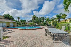 a patio with a table and chairs next to a pool at 4 Mi to Siesta Key Beach Condo with Pool Access in Sarasota