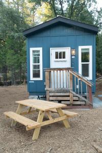 グローブランドにあるTiny House Yosemiteの青い小さな家の前のピクニックテーブル