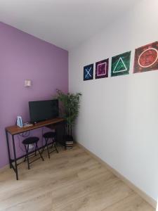 a room with a desk with a computer and paintings on the wall at Le Nid du Haut in Saint-Nectaire