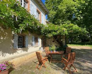 a table and chairs in front of a house at Domaine Rauly in Puygaillard-de-Quercy