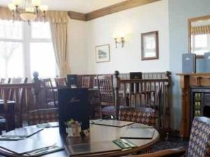 a dining room with tables and chairs and a window at The Quay Inn in Minehead