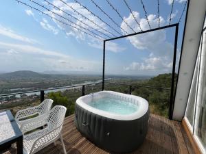 a hot tub on a deck with a table and chairs at Doel House Zues - Hot Tub Villa & Scenic View in Shkodër