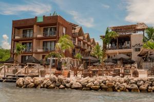 a resort with chairs and umbrellas next to the water at AWA Holbox Hotel Boutique - Beach Front in Holbox Island +54 photos