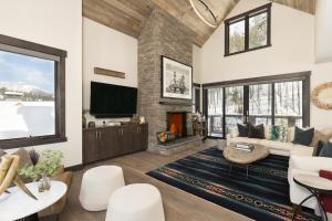 a living room with a fireplace and a tv at Spanish Peaks | Highlands Cabin 36 in Big Sky