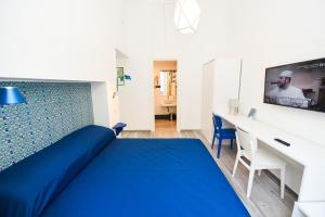 ソレントにあるLa Torre Relais Sorrentoのベッドルーム(青いベッド1台、デスク付)