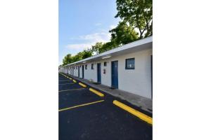 una fila di edifici bianchi con porte blu di Motel 19 By Townhouse Baytown I-10 a Baytown