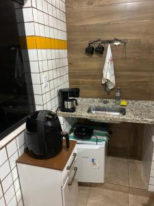 a small kitchen with a counter and a sink at Chalé Jorge in São Thomé das Letras