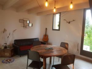 a living room with a table and a couch at Le colibri du Luberon in Apt