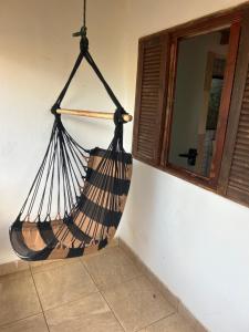 a hammock hanging from a wall next to a window at Chalé Jorge in São Thomé das Letras