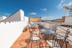Un balcón con sillas y una mesa en un tejado. en Casa Nana Townhouse with seaview, en Torrox