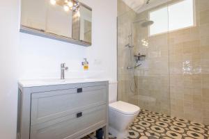 Un baño con lavabo, inodoro y ducha. en Casa Nana Townhouse with seaview, en Torrox