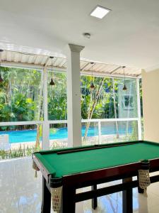 a pool table in a room with a swimming pool at Pousada DOliver in Paraty
