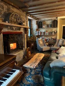 sala de estar con chimenea y piano en The Writers Den, en Nairn