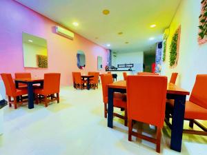 une salle à manger avec des tables et des chaises orange dans l'établissement Playa Norte Hotel, à Carthagène des Indes
