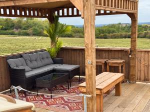 a wooden gazebo with a couch and a table at Asila's Ark in Keyworth