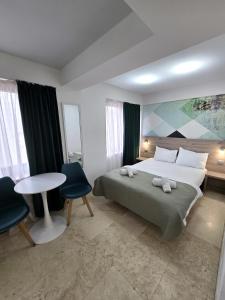 a bedroom with a bed and a table and chairs at Dacia Residence Apartments in Bucharest
