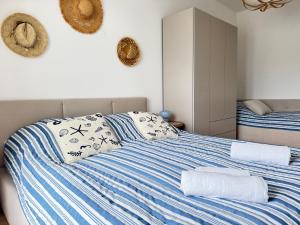 a bedroom with a bed with blue and white stripes at Apartament Sunset Resort Grzybowo in Grzybowo