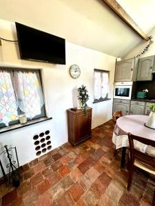 a living room with a table and a tv on the wall at Charme ancien pigeonnier au cœur de la campagne in Ourouer-lès-Bourdelins