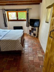 a bedroom with a bed and a flat screen tv at Charme ancien pigeonnier au cœur de la campagne in Ourouer-lès-Bourdelins +11 photos