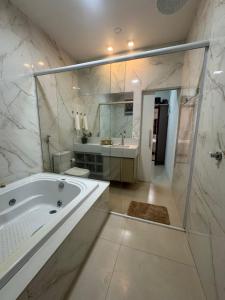 a bathroom with a tub and a shower and a sink at Casa Canto do Araguaia in Barra do Garças