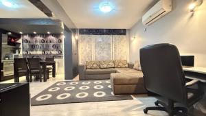 a living room with a couch and a desk and a table at Geneva Suite in Zlatograd