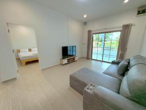 a living room with a couch and a television at Rest25 Betong in Ban Komo Sip Paet