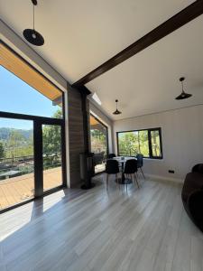 a living room with a table and chairs and large windows at Petrick House in Verkhovyna