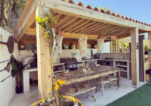 an outdoor kitchen with a wooden table and chairs at La tanière in Les Brugassières +4 photos