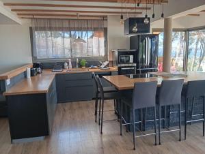 a kitchen with a island with bar stools at Villa vu mer et étang de thau in Sète