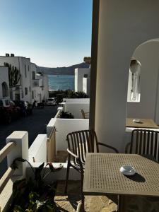 a table and chairs on a balcony with a view of the ocean at ALTHEA suites in Naousa +23 photos