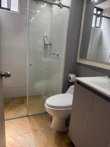 a bathroom with a shower and a toilet and a sink at Sabana Stay in Tocancipá +4 photos