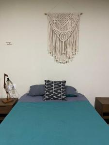 a bed with two pillows on top of it at Villa La Toscana Yucateca Encanto Italiano en Mérida in Mérida