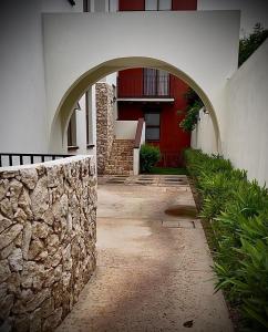 an archway leading to a building with a red door at Villa La Toscana Yucateca Encanto Italiano en Mérida in Mérida +12 photos
