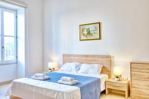 a bedroom with a bed with towels on it at Charming Maltese Maisonette in Sliema