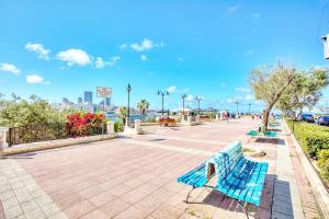 a blue bench sitting on a sidewalk in a park at Charming Maltese Maisonette in Sliema