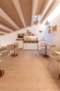 a room with tables and chairs and a kitchen at Bed and Breakfast Nilu' in Castellammare del Golfo