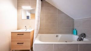 a bathroom with a white tub and a sink at Spacieux T2 Place de la République in Dijon