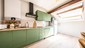 a kitchen with green cabinets and a window at Spacieux T2 Place de la République in Dijon +18 photos