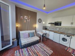 a living room with a couch and a table and a kitchen at Les Sureaux - Hyper-Centre - Design & WiFi - Idéal Visite Perpignan in Perpignan
