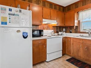 Una cocina con electrodomésticos blancos y gabinetes de madera. en 4085 - Ten Forward, en Kitty Hawk