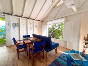 a dining room with a table and blue chairs at Beautiful beach cabin for two in Providencia