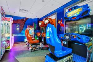a childs room with a video game arcade at Magnificent Home Near Disney With Theater Room, Pool Table, Waterpark & Resort Access At Encore Resort Reunion - 7448Mr in Kissimmee