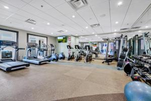 a gym with treadmills and machines in a room at Magnificent Home Near Disney With Theater Room, Pool Table, Waterpark & Resort Access At Encore Resort Reunion - 7448Mr in Kissimmee