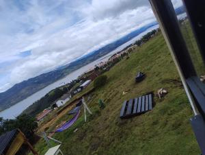 a group of people standing on a hill near a river at Zona de camping zoe in Guatavita +3 photos