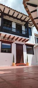 ein Gebäude mit einem Balkon und einer Holztür in der Unterkunft Casa Encanto in Villa de Leyva