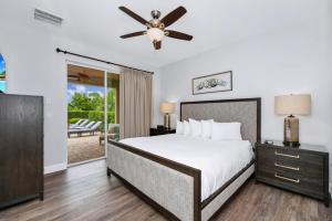 une chambre avec un lit et un ventilateur de plafond dans l'établissement Grand Home Near Disney With Private Pool And Waterpark & Resort Access At Encore Resorts Reunion - 7519Mr, à Kissimmee