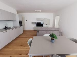 eine Küche und ein Wohnzimmer mit einem weißen Tisch und Stühlen in der Unterkunft Fly Residence Venice in Venedig