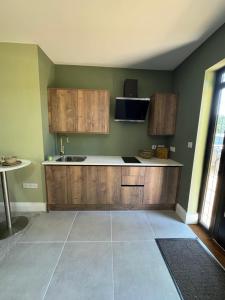 a kitchen with wooden cabinets and a sink at West Lodge in Wythall
