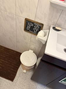 a bathroom with a toilet and a sign on the wall at Casa Nova in Apúlia +36 photos