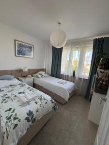 a bedroom with two beds and a large window at Nocleg na doby S 61 ROAD in Suwałki